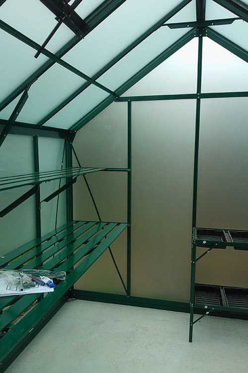 Interior of a Trulux glasshouse showing roof vents and integrated shelving